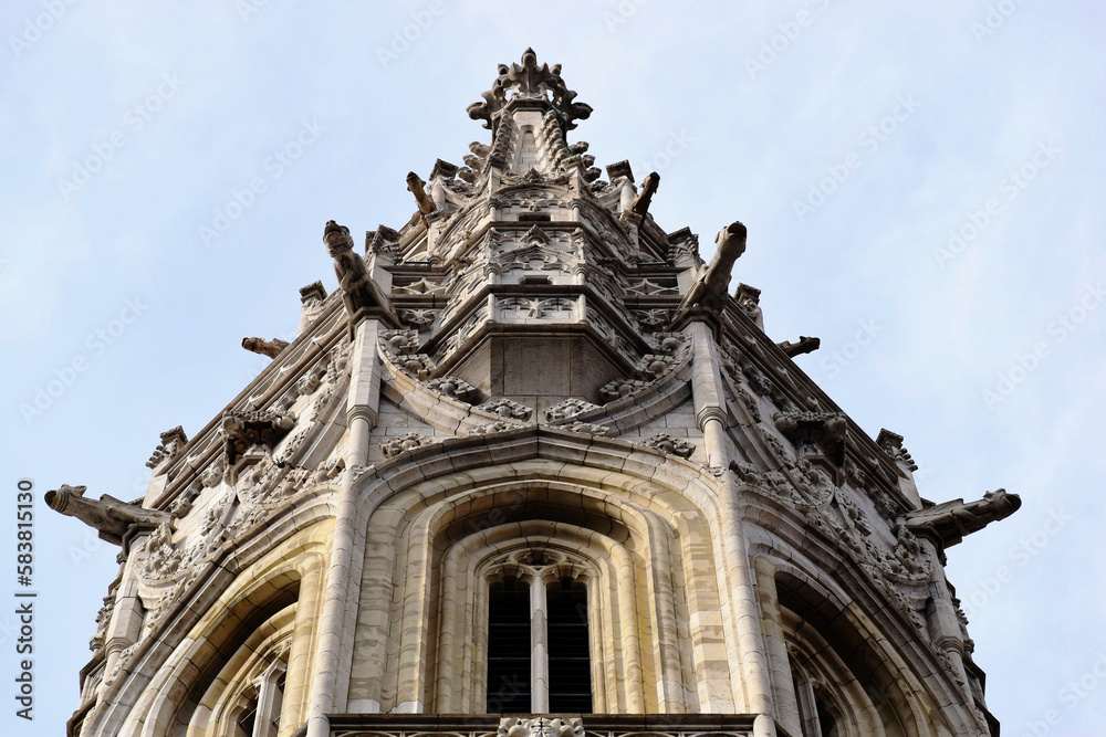 stone church tower closeup in diminishing perspective. the Matthias church in Budapest. ornate sculpted gargoyles. arched Gothic windows. famous landmark in Budapest. low angle view. old architecture
