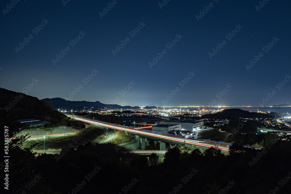 道路の光跡と町の夜景　愛知県