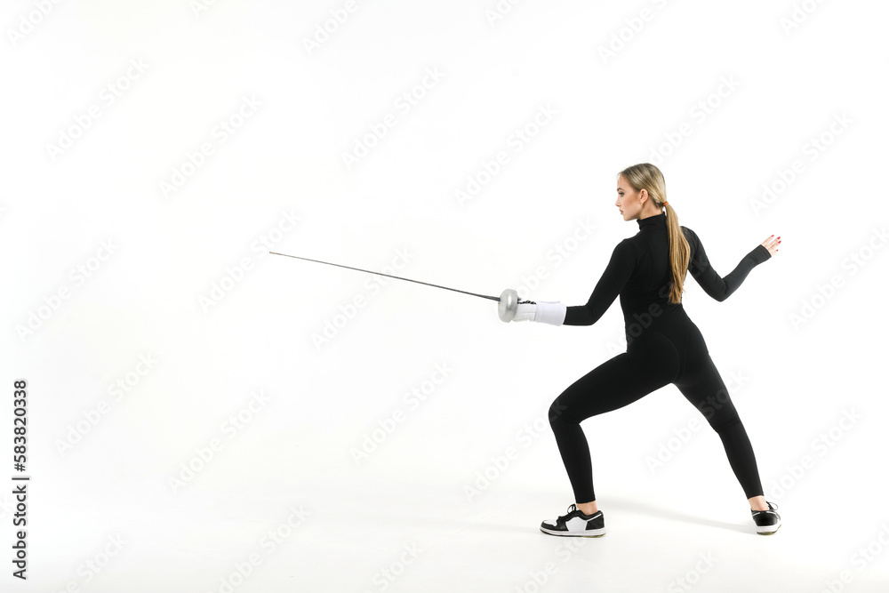 Girl in a black tight-fitting jumpsuit practicing with a sword on a white background Girl in a black tight-fitting jumpsuit practicing with a sword on a white background