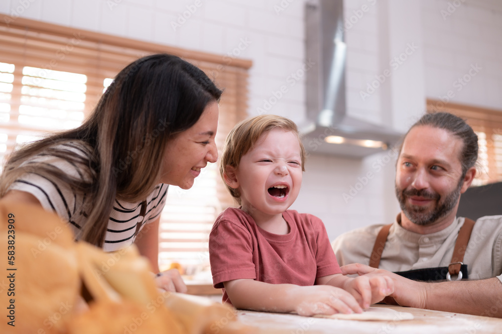 Mom and dad in the kitchen of the house with their small children. Have a good time baking bread and making dinner together. Mom and dad in the kitchen of the house with their small children. Have a good time baking bread and making dinner together.