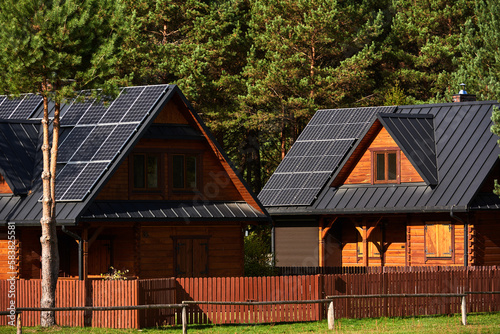 photovoltaic installation on the roofs of wooden houses in the forest