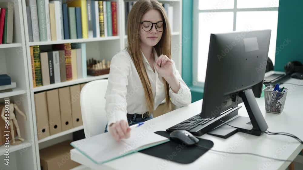 Young blonde woman student using computer writing on notebook at university classroom Young blonde woman student using computer writing on notebook at university classroom