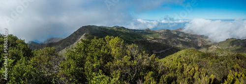 Panoramic view from Baracan mountain. Green forest, hills and valley with terraced fields and village Las Portelas at Park rural de Teno, Tenerife, Canary Islands, Spain. sunny day, blue sky photo