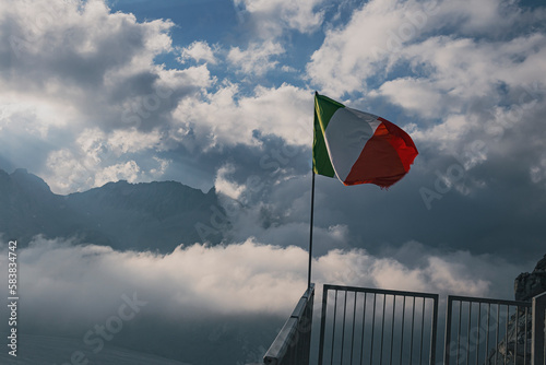 flag of italy in the alps on a cloudy day