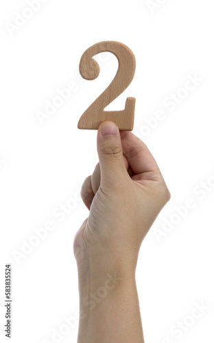 Hand holding wooden number 2