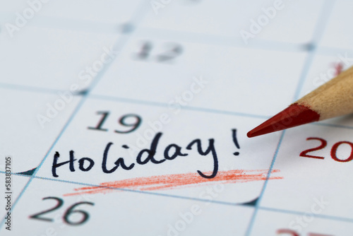 Word holiday written on calendar