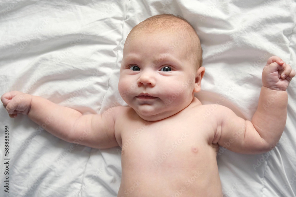 Closeup portrait of Newborn baby on white blanket. Soft focus. Infant is lying, yawning. One, two week age. Infant girl waking up on bed at home. New life and growing up concept. Real People Closeup portrait of Newborn baby on white blanket. Soft focus. Infant is lying, yawning. One, two week age. Infant girl waking up on bed at home. New life and growing up concept. Real People