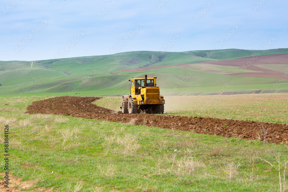 Traktok plows the land, preparing for sowing seeds. Industrial agriculture and farming. Tractor driver at work in the field. Harvesting, harvester harvests. Traktok plows the land, preparing for sowing seeds. Industrial agriculture and farming. Tractor driver at work in the field. Harvesting, harvester harvests.