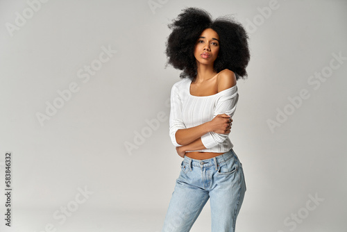Attractive african american girl with an afro hairstyle isolated on gray background