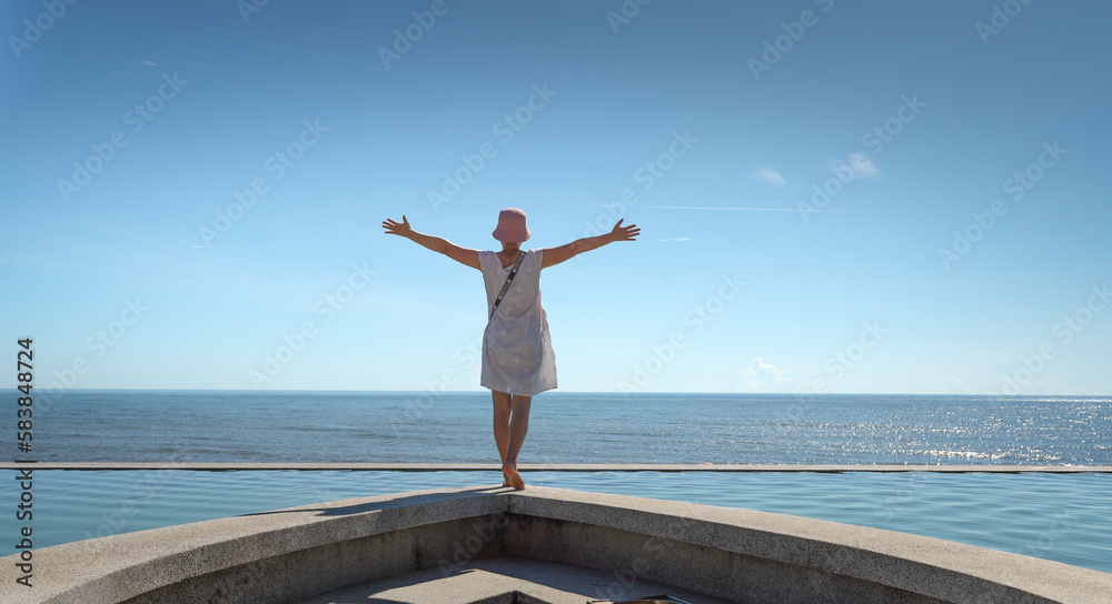 A female tourist is excited at the infinity pool overlooking the sea at the four-star Quynh Vien Resort, Ha Tinh provice, Vietnam A female tourist is excited at the infinity pool overlooking the sea at the four-star Quynh Vien Resort, Ha Tinh provice, Vietnam