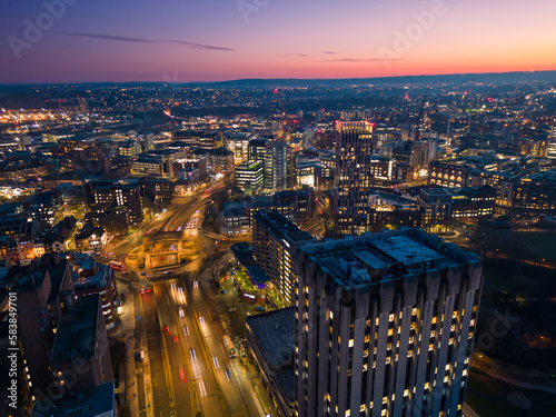 Aerial view of a modern city skyscraper illuminated during a colourful sunset