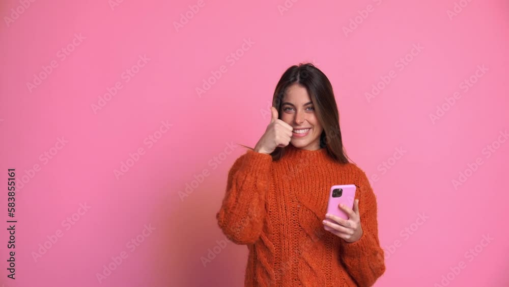 Smiling woman with smartphone against pink background Smiling woman with smartphone against pink background