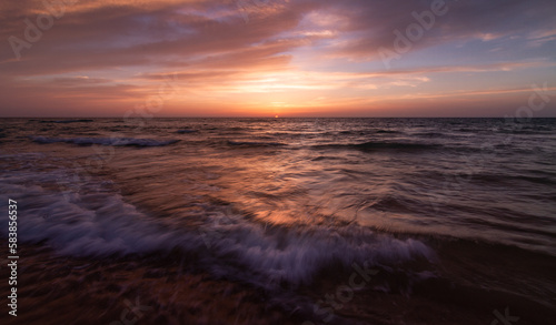 Sunset over the sea shore  sandy beach  colorful sky