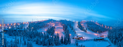 Winter dusk over the snowy ski slopes of Ruka tourist resort, aerial view, Kuusamo, Northern Ostrobothnia, Lapland photo