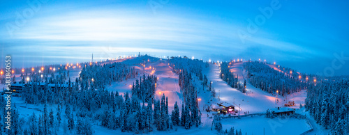 Winter dusk over the snowy ski slopes of Ruka tourist resort, aerial view, Kuusamo, Northern Ostrobothnia, Lapland