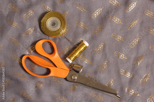 Spool of Metallic Gold Thread on Gray and Gold Chiffon Fabric