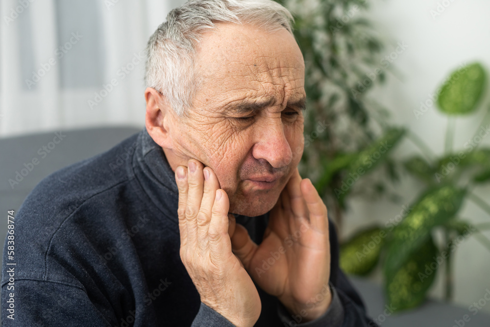 Elderly Man Having Toothache Touching Cheek Suffering From Pain Sitting On Sofa At Home. Elderly Man Having Toothache Touching Cheek Suffering From Pain Sitting On Sofa At Home.