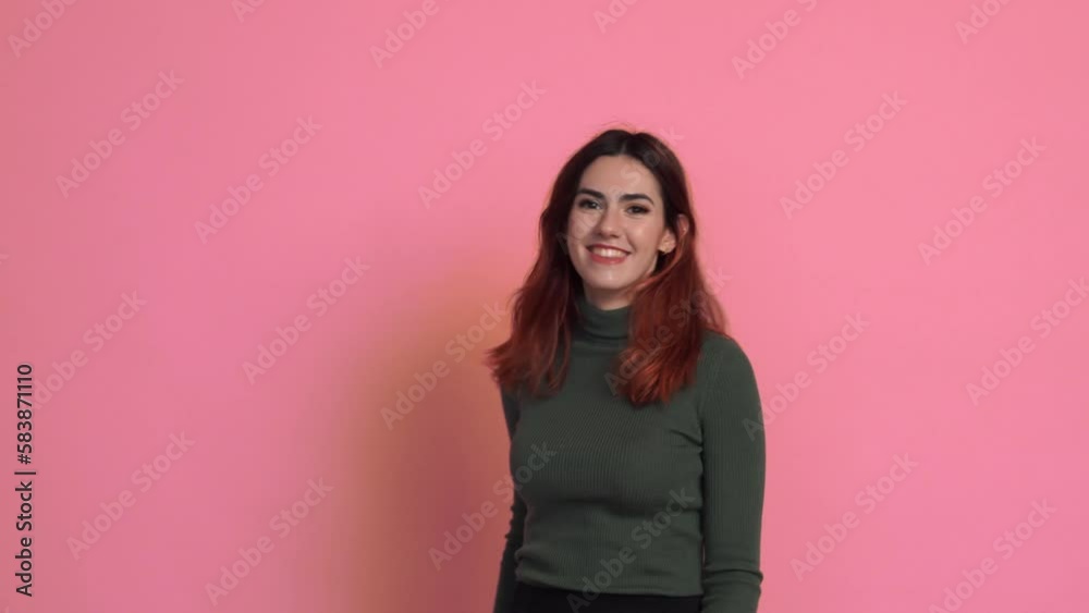 Smiling woman in sweater showing heart gesture