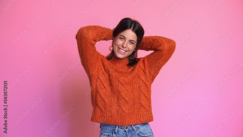 Smiling woman in sweater against pink background Smiling woman in sweater against pink background