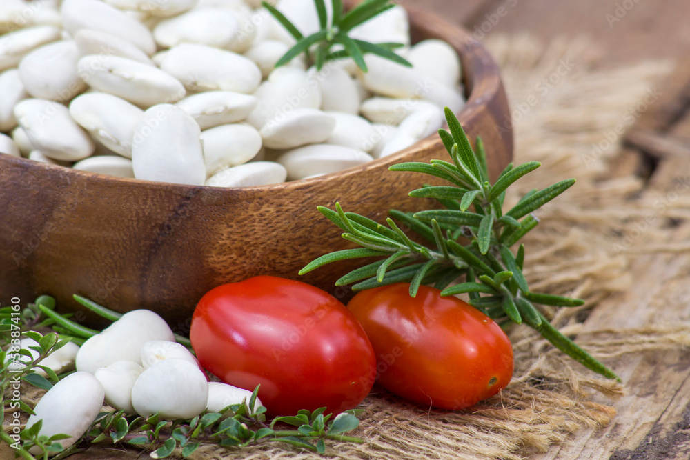 white beans, tomatoes and herbs on wooden background white beans, tomatoes and herbs on wooden background