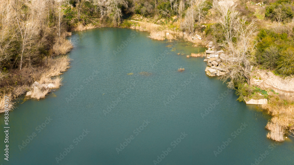 Aerial view of a natural swimming lake with spring water. There is no one and the pond is empty.