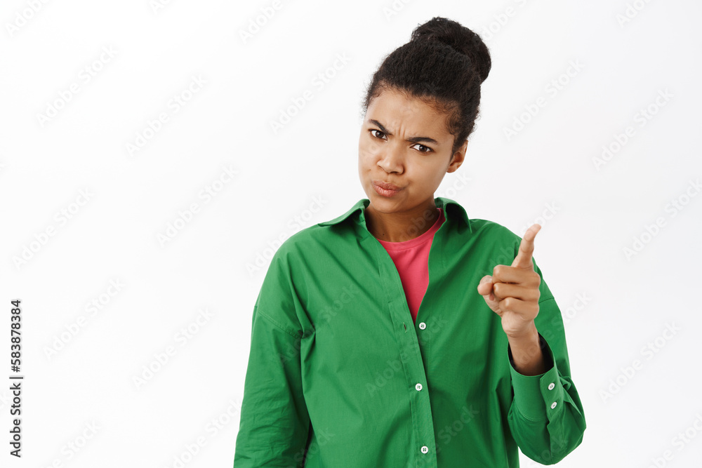 Portrait of angry, disappointed woman shaking finger in disapproval, scolding you, forbid smth bad, white studio background Portrait of angry, disappointed woman shaking finger in disapproval, scolding you, forbid smth bad, white studio background