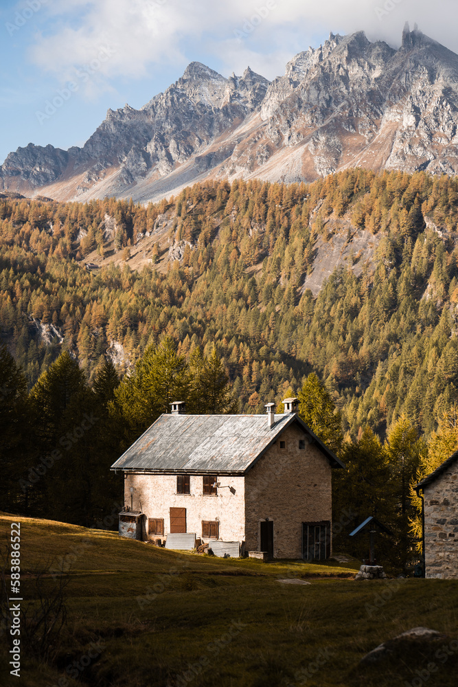 A mountain hut in the highland of Alpe Devero, Northern Italy, with high peaks in the background