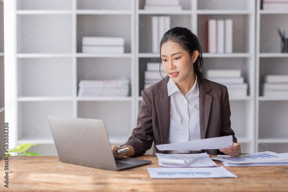 Business Asian woman working at office with documents on her desk, calculator to calculate planning analyzing the financial report, business plan investment, finance analysis concept Business Asian woman working at office with documents on her desk, calculator to calculate planning analyzing the financial report, business plan investment, finance analysis concept