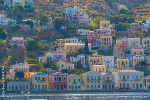 View of clourful houses overlooking harbour of Symi Town, Symi Island, Dodecanese, Greek Islands photo