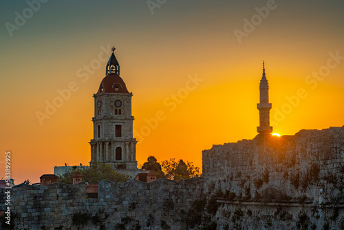 View of sunrise between Medieval Clock Tower and Mosque of Suleiman, UNESCO World Heritage Site, Rhodes Town, Rhodes, Dodecanese Island Group, Greek Islands photo