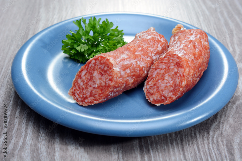 Salami Wurst mit Petersilie auf einem Tisch Salami Wurst mit Petersilie auf einem Tisch