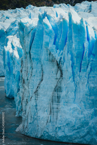vertical close up of iceberg glacier under hot sun in Antarctica , glacier melting causing rising sea level global warming climate change concept
