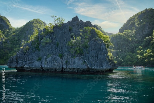 Majestic rocks in Coron, Palawan in the Philippines that are overgrown with shrubs and rise out of the water. © Monika