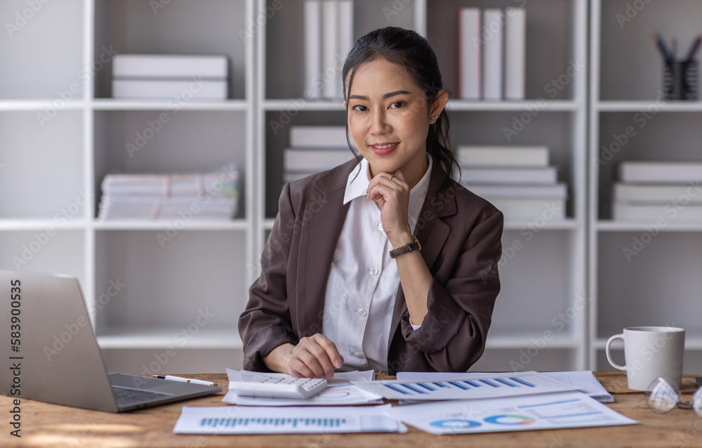 Asian Businesswoman Using laptop computer and working at office with calculator document on desk, doing planning analyzing the financial report, business plan investment, finance analysis concept.
Asian Businesswoman Using laptop computer and working at office with calculator document on desk, doing planning analyzing the financial report, business plan investment, finance analysis concept.