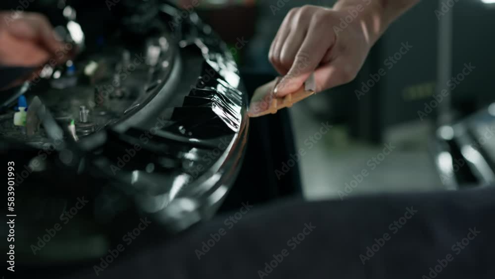 Gluing the film on the spoiler to protect the paint which protects the