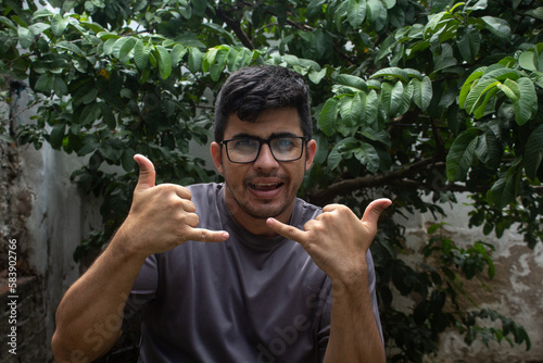 Young man in eyeglasses making sign with hands demonstrating happiness