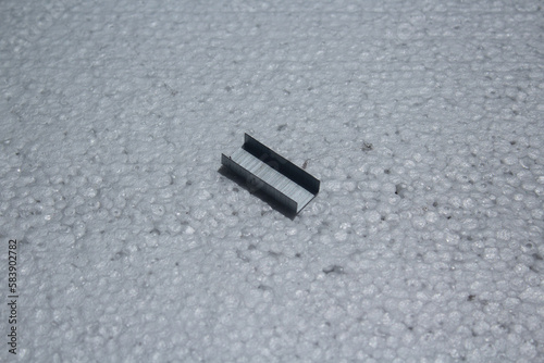 portion of metal staples on a white background