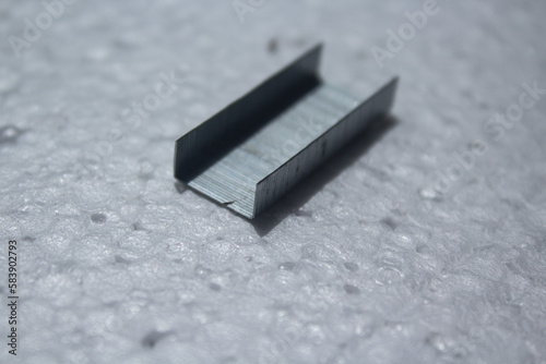 portion of metal staples on a white background
