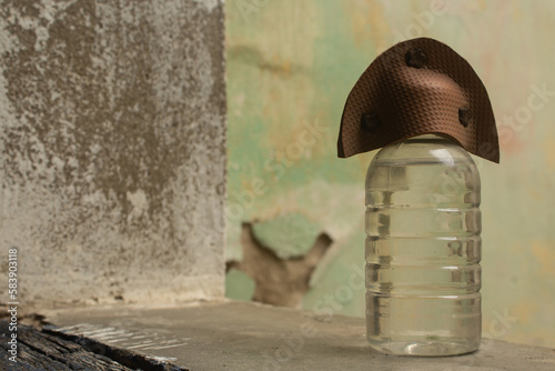 bottle of water in a window with the lid shaped like a typical northeastern Brazilian hat