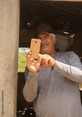 Mature man using cell phone to take photo
