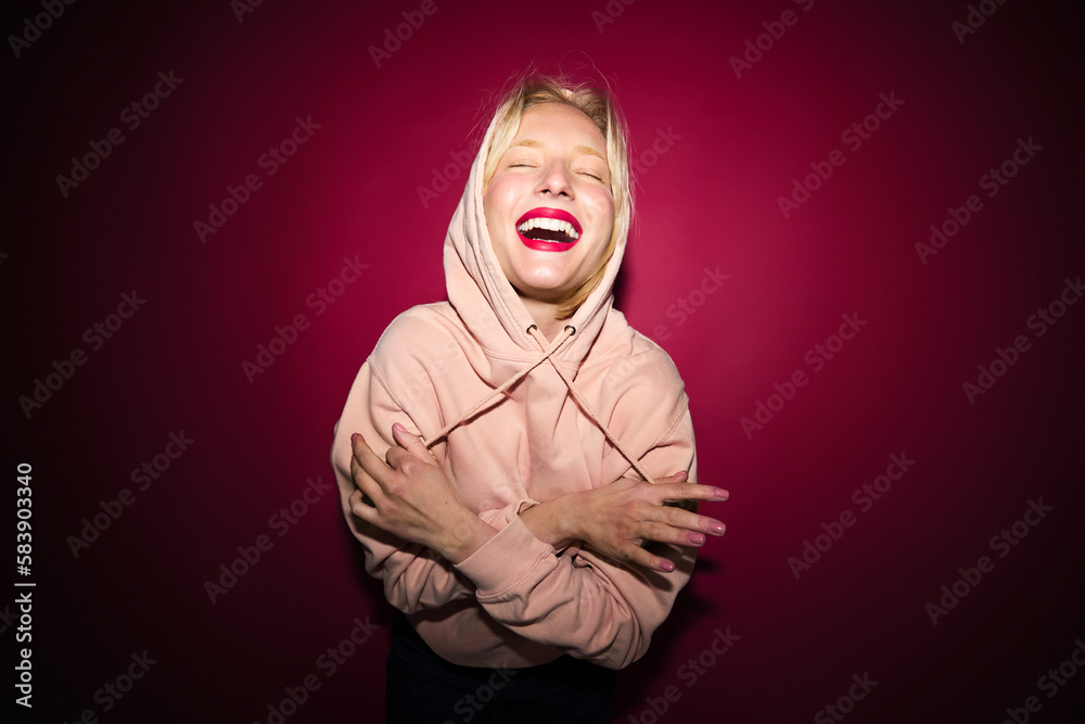 A cheerful woman dancing and having fun isolated on magenta background. Viva magenta, color of the year. A cheerful woman dancing and having fun isolated on magenta background. Viva magenta, color of the year.