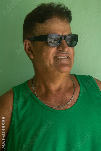 Portrait of a mature man wearing sunglasses and a green shirt