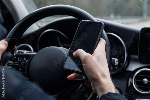 Man ignoring safety and using mobile phone while driving car