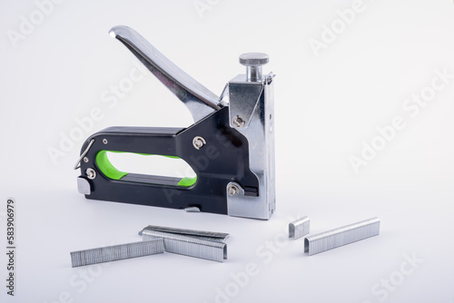 Industrial and home mechanical Stapler and brad gun with a range of different types of stapels brads isolated on a white background photo