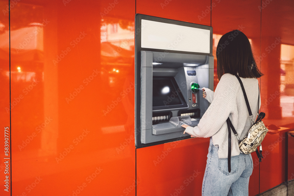 Woman inserting her card in the ATM machine, making a cash withdrawal Woman inserting her card in the ATM machine, making a cash withdrawal