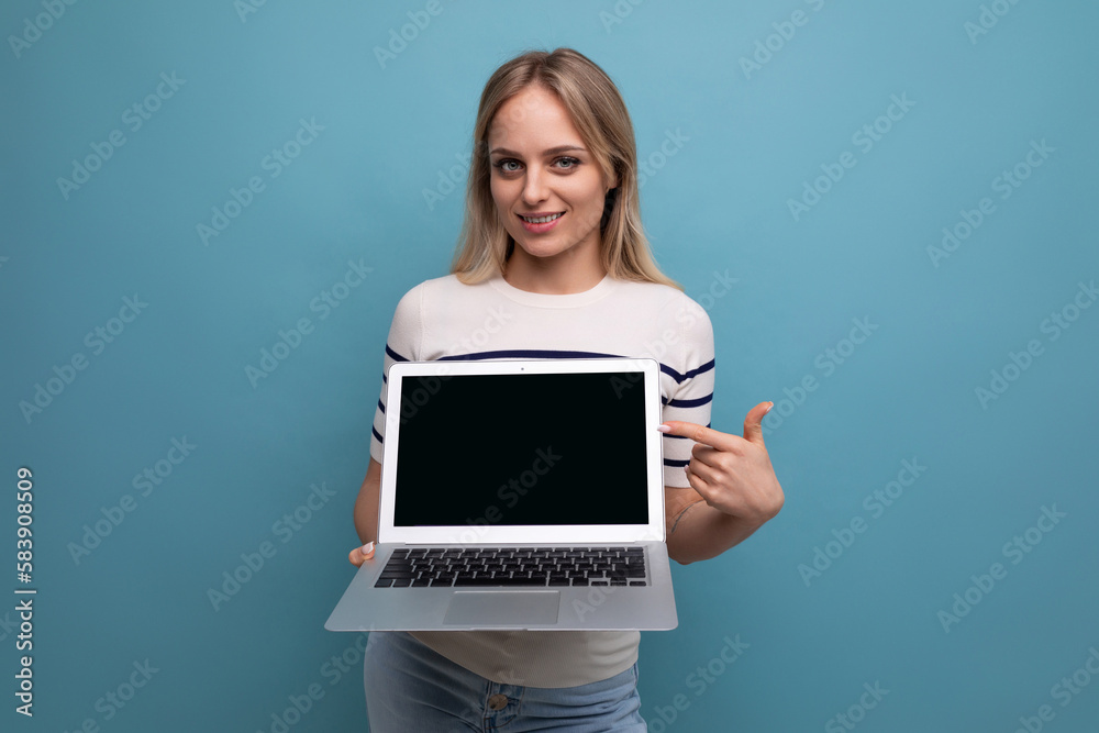 focused woman showing laptop screen with mockup on blue background focused woman showing laptop screen with mockup on blue background