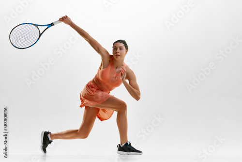 Portrait of young sportive woman, professional female tennis player in uniform with racket, training against white studio background. Concept of professional sport, movement, health, action. Ad © master1305