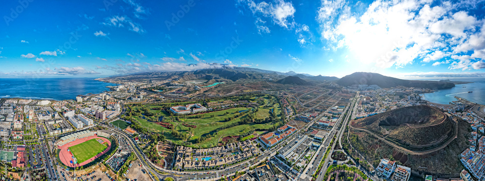 Aerial panoramic view above golf course surrounded by villas, condos and resort in Playa las Americas, Tenerife, Canary Islands Spain