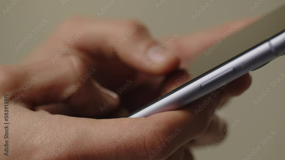 Cropped view of a man using his smartphone. A man holds a smartphone in his hands and types a message. Phone user chatting with someone Cropped view of a man using his smartphone. A man holds a smartphone in his hands and types a message. Phone user chatting with someone