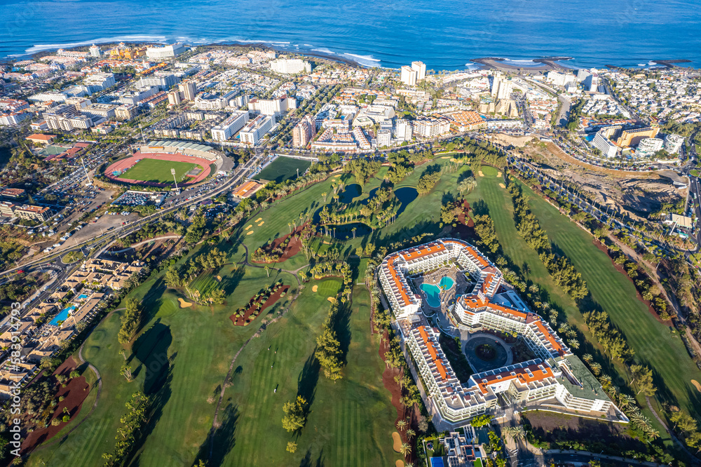 Aerial view above golf course surrounded by villas, condos and resort in Playa las Americas, Tenerife, Canary Islands Spain
